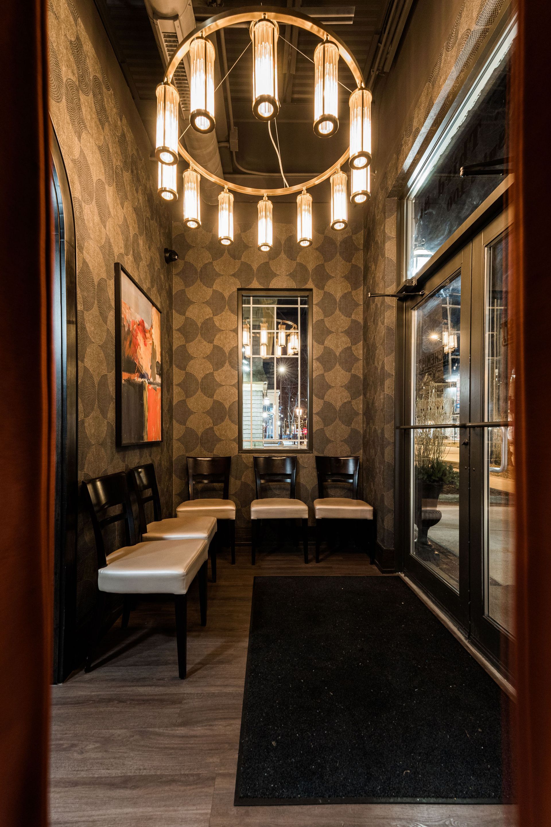 A waiting room with chairs and a chandelier hanging from the ceiling.