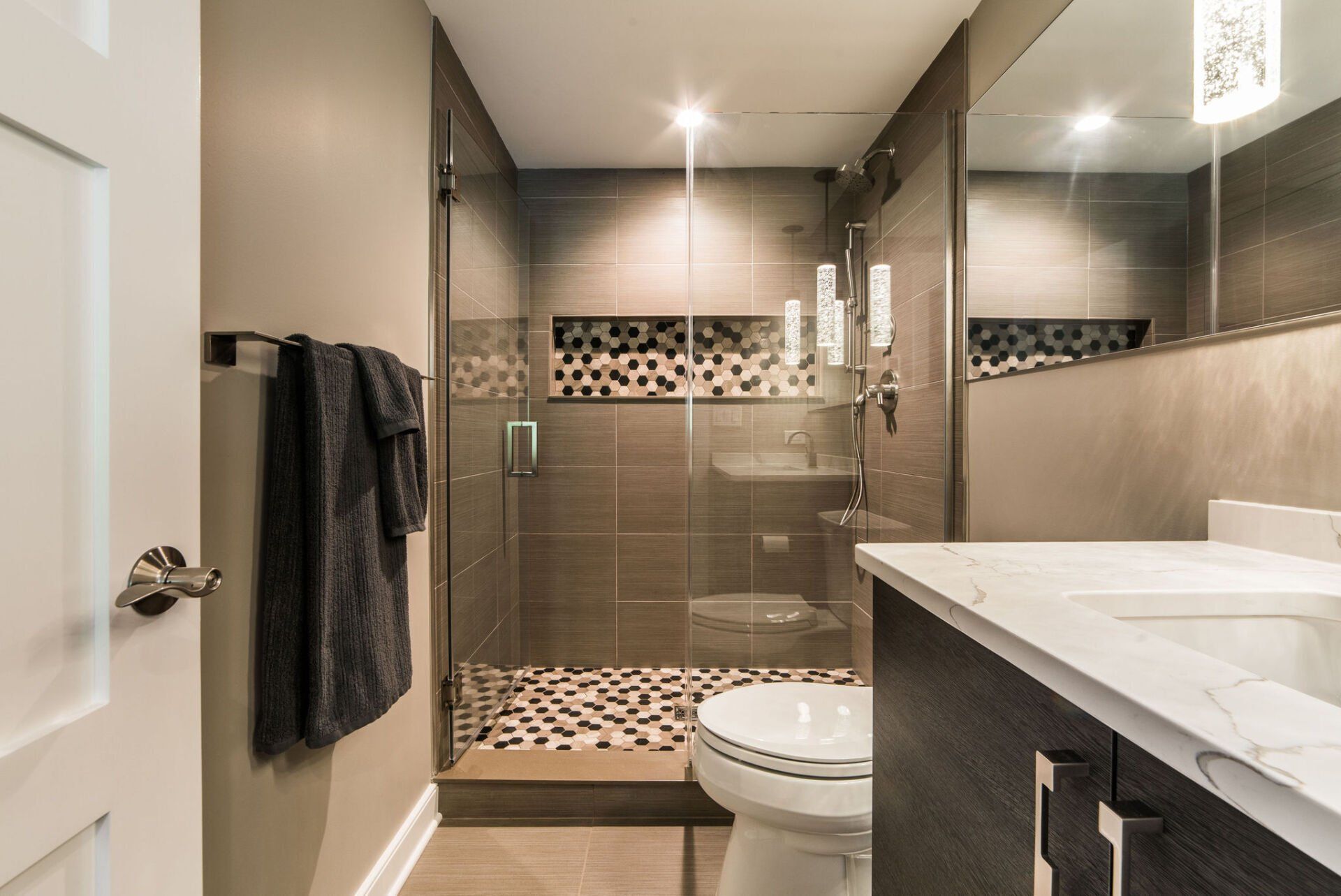 A bathroom with a toilet , sink and walk in shower.