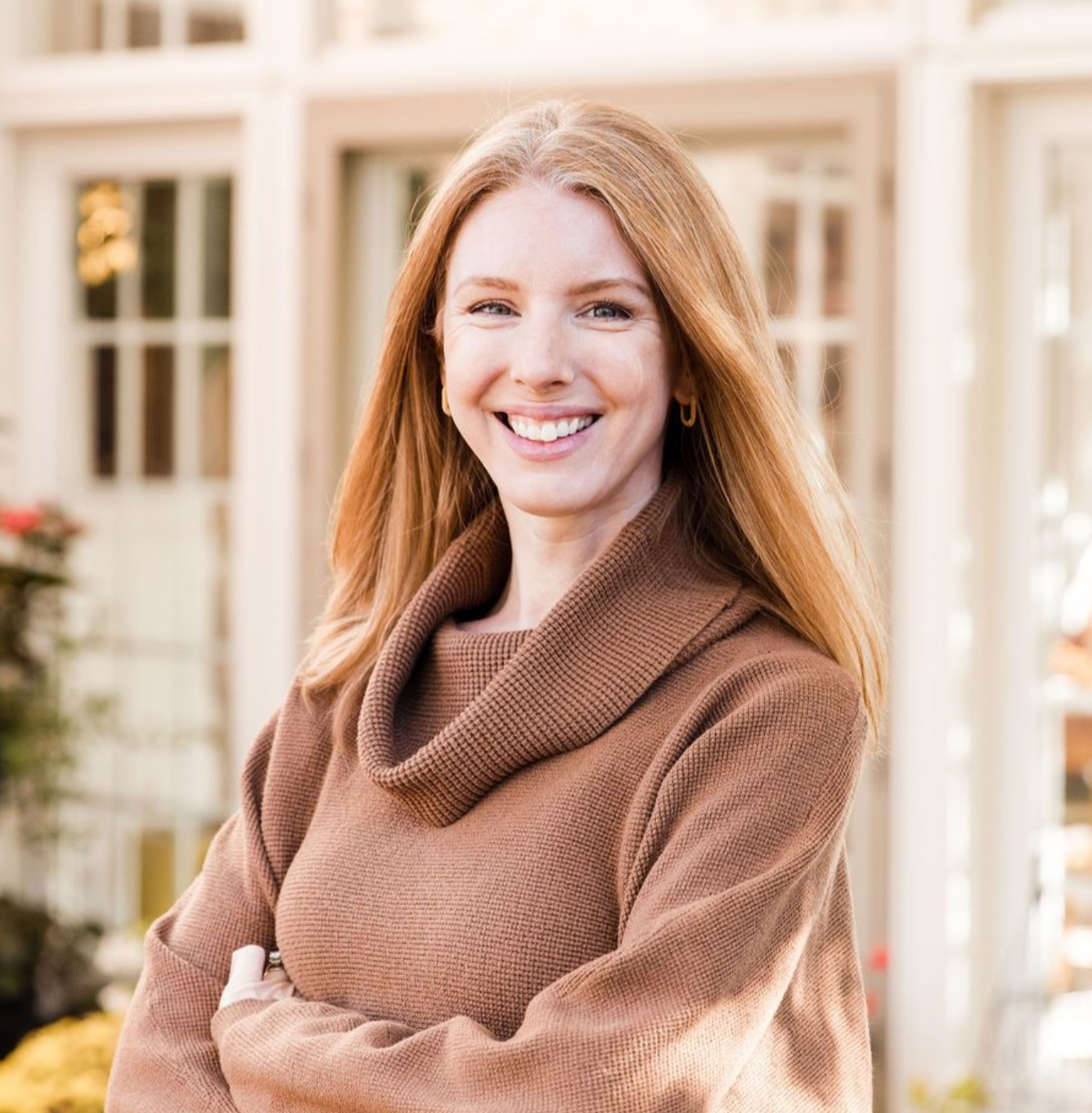 A woman in a brown shirt is smiling for the camera.