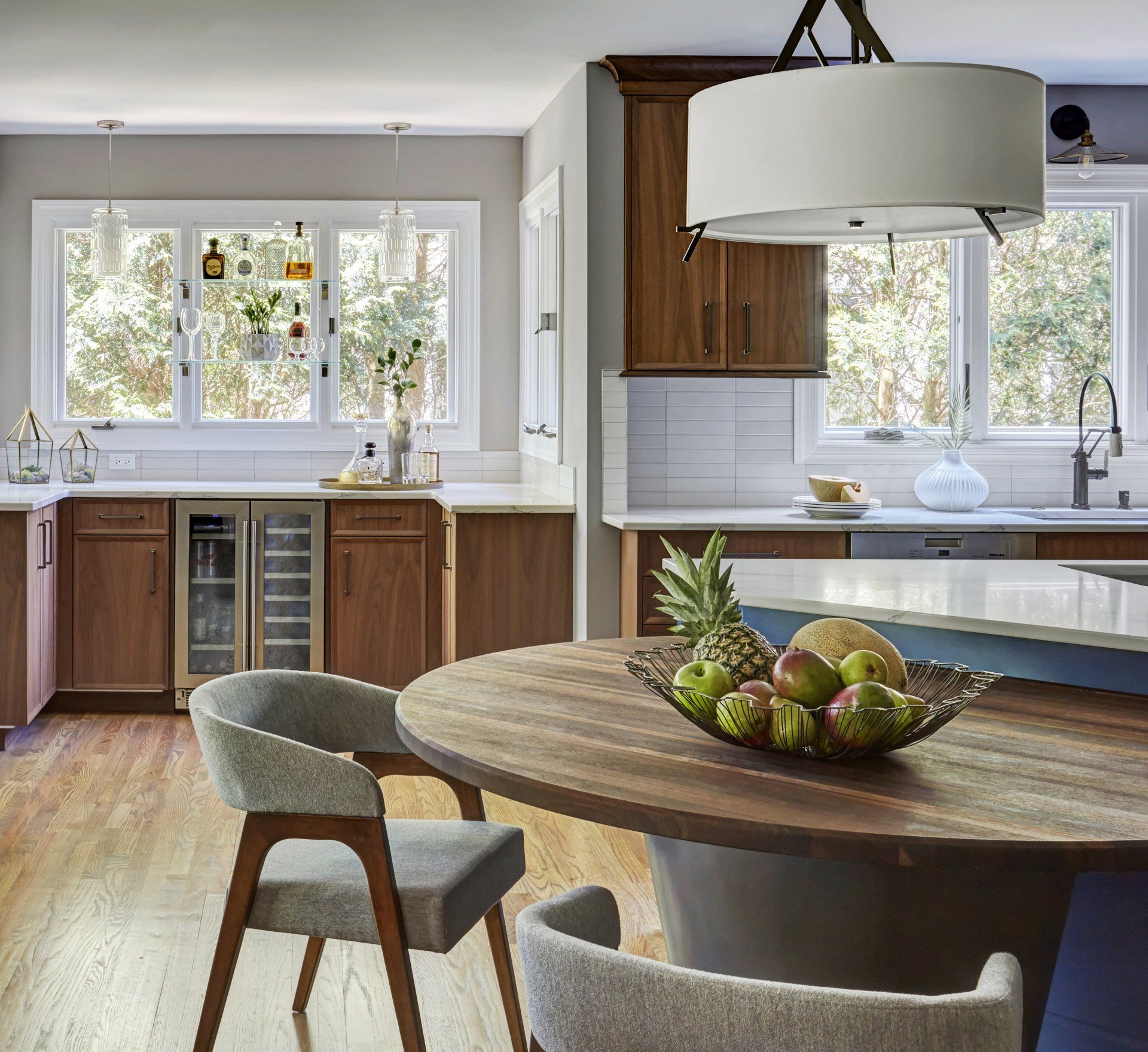 A kitchen with a bowl of fruit on the table