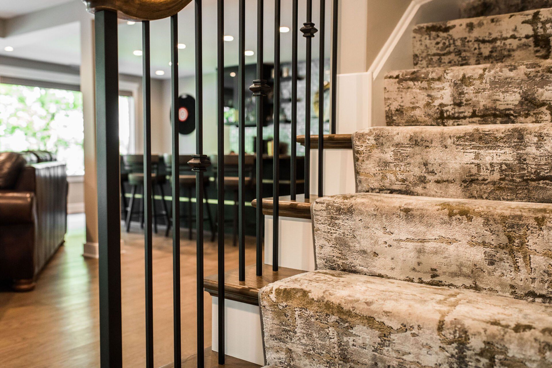 A staircase with a carpeted staircase and a metal railing in a house.