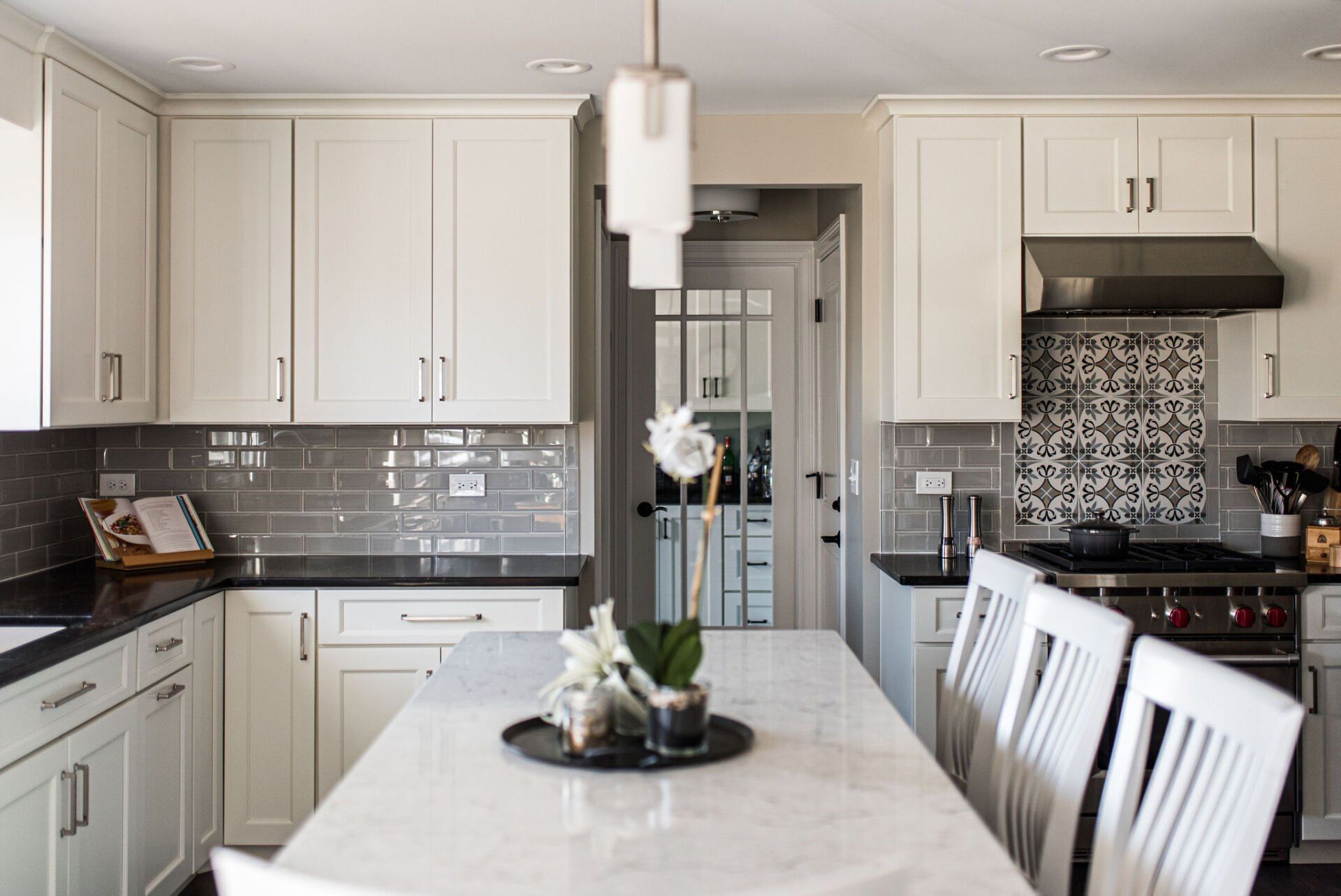 A kitchen with white cabinets and a dining table