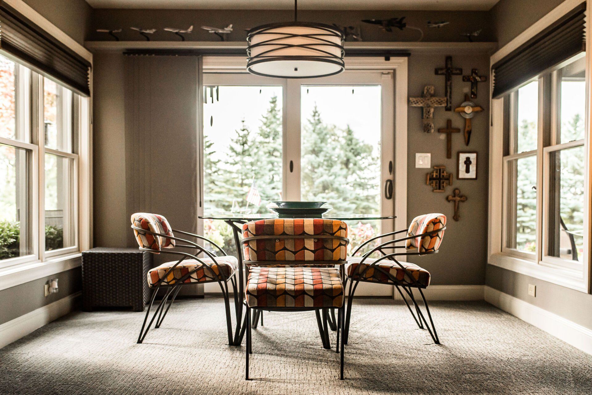 A dining room with a table and chairs and a large window.
