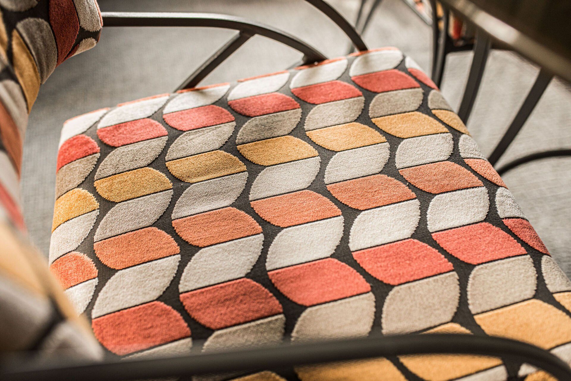 A close up of a chair with a colorful pattern on it.
