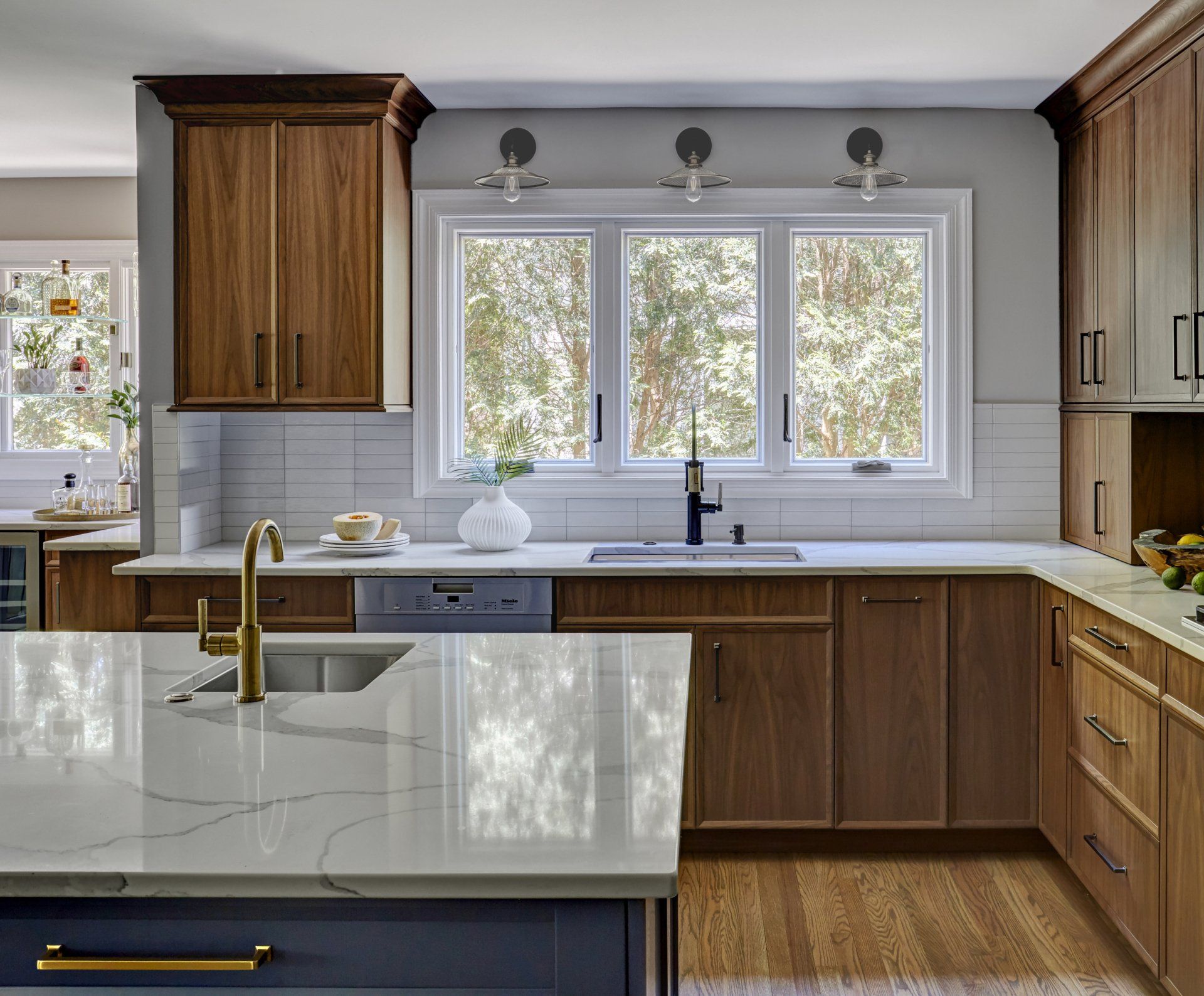 A kitchen with wooden cabinets , a sink , and a large island.