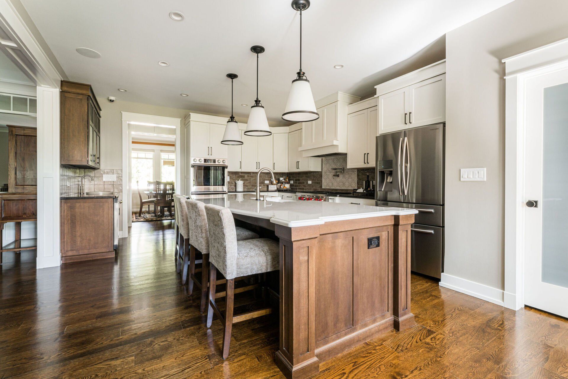 A kitchen with a large island in the middle and stainless steel appliances.