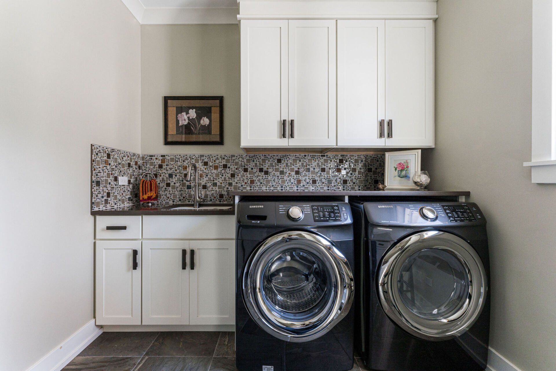 A laundry room with two washing machines and a sink.
