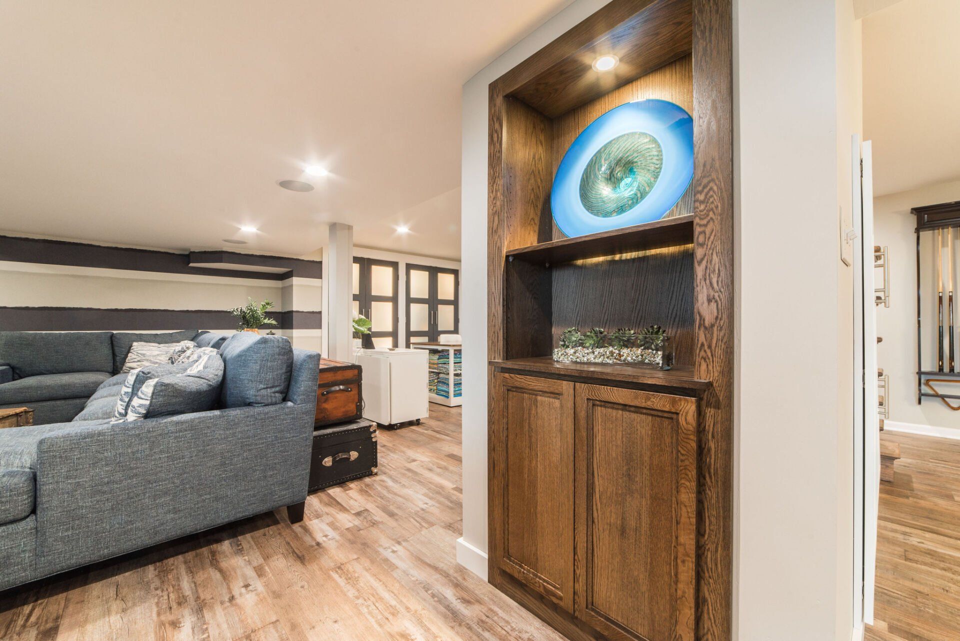 A living room with a couch and a shelf with a plate on it.