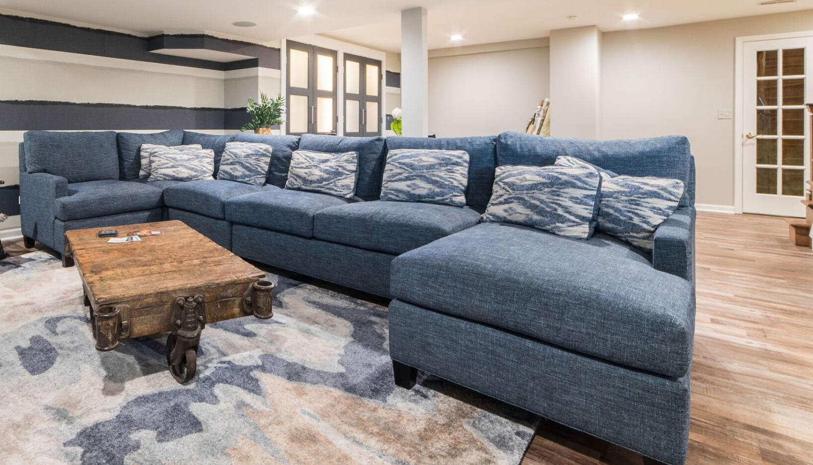 A living room with a blue sectional couch and a wooden coffee table.