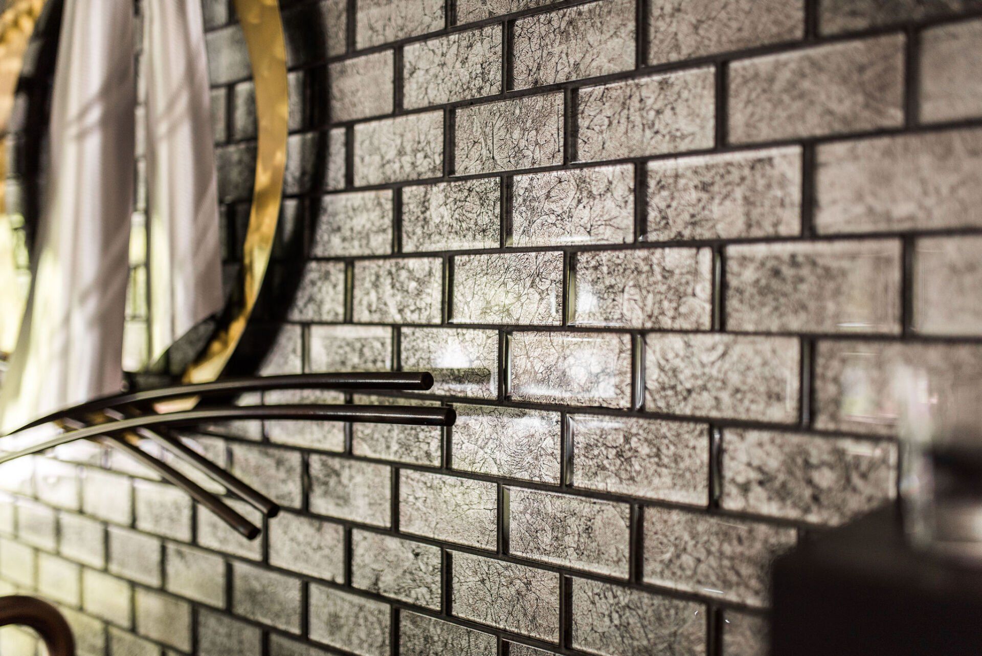 A close up of a brick wall with a mirror on it.
