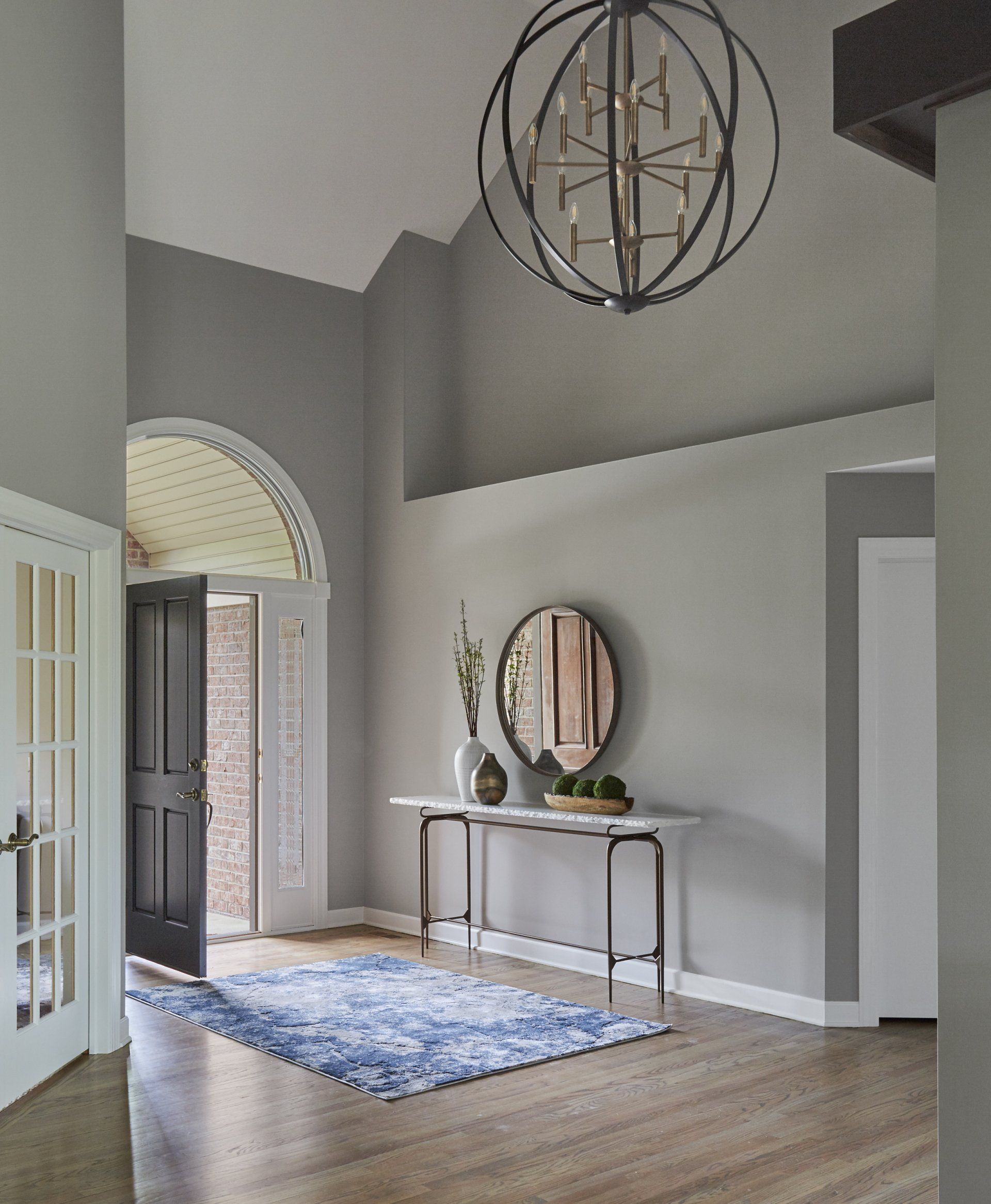 A hallway with a table and a mirror in it