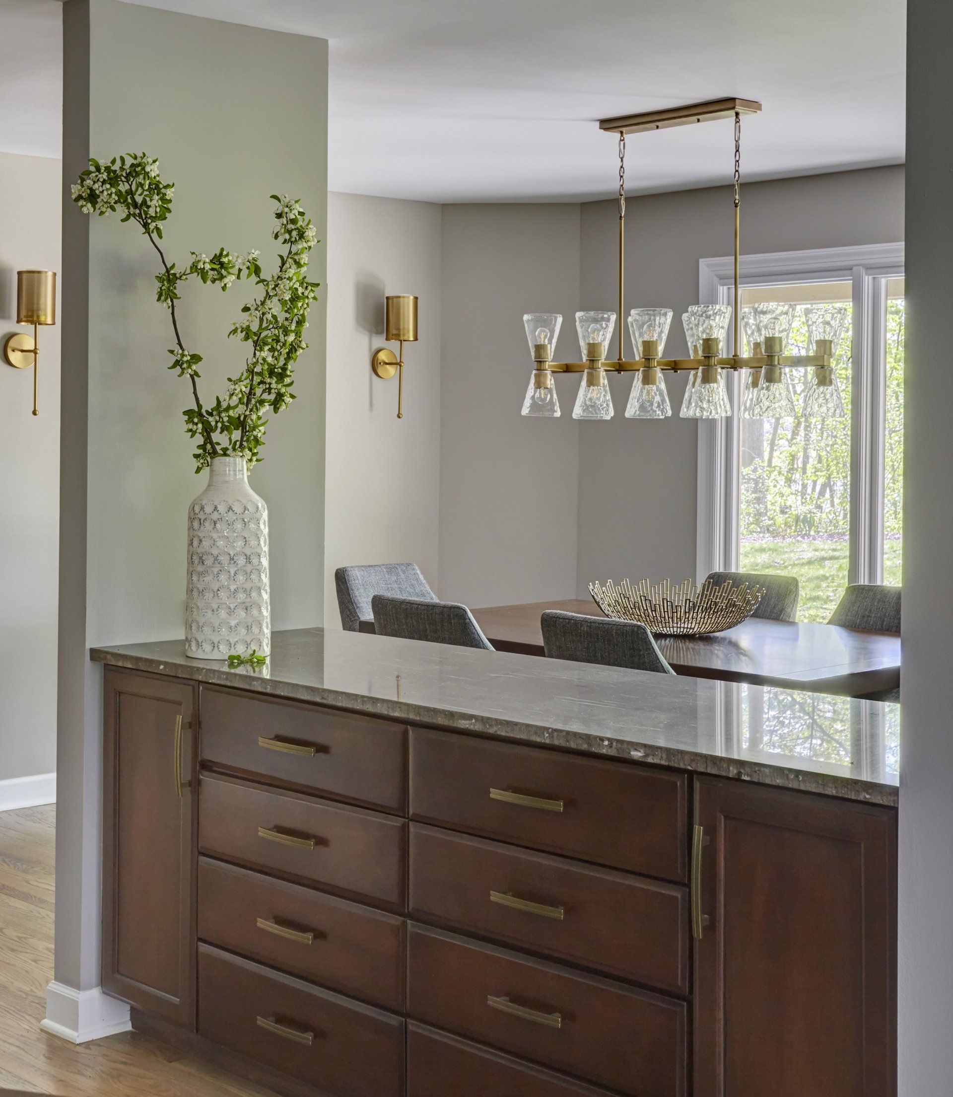 A kitchen with wooden cabinets and a marble counter top.