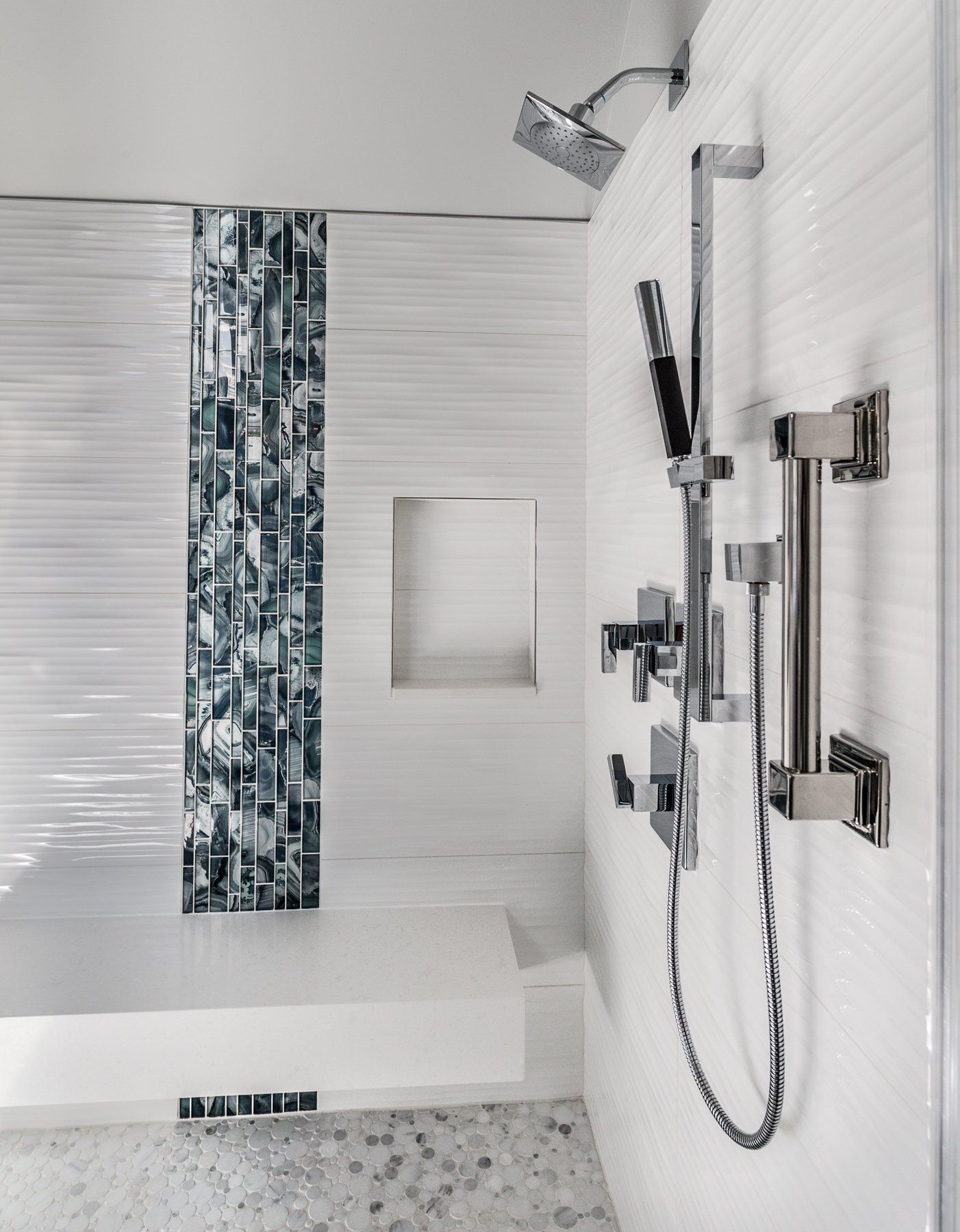 A bathroom with white tiles and a shower head