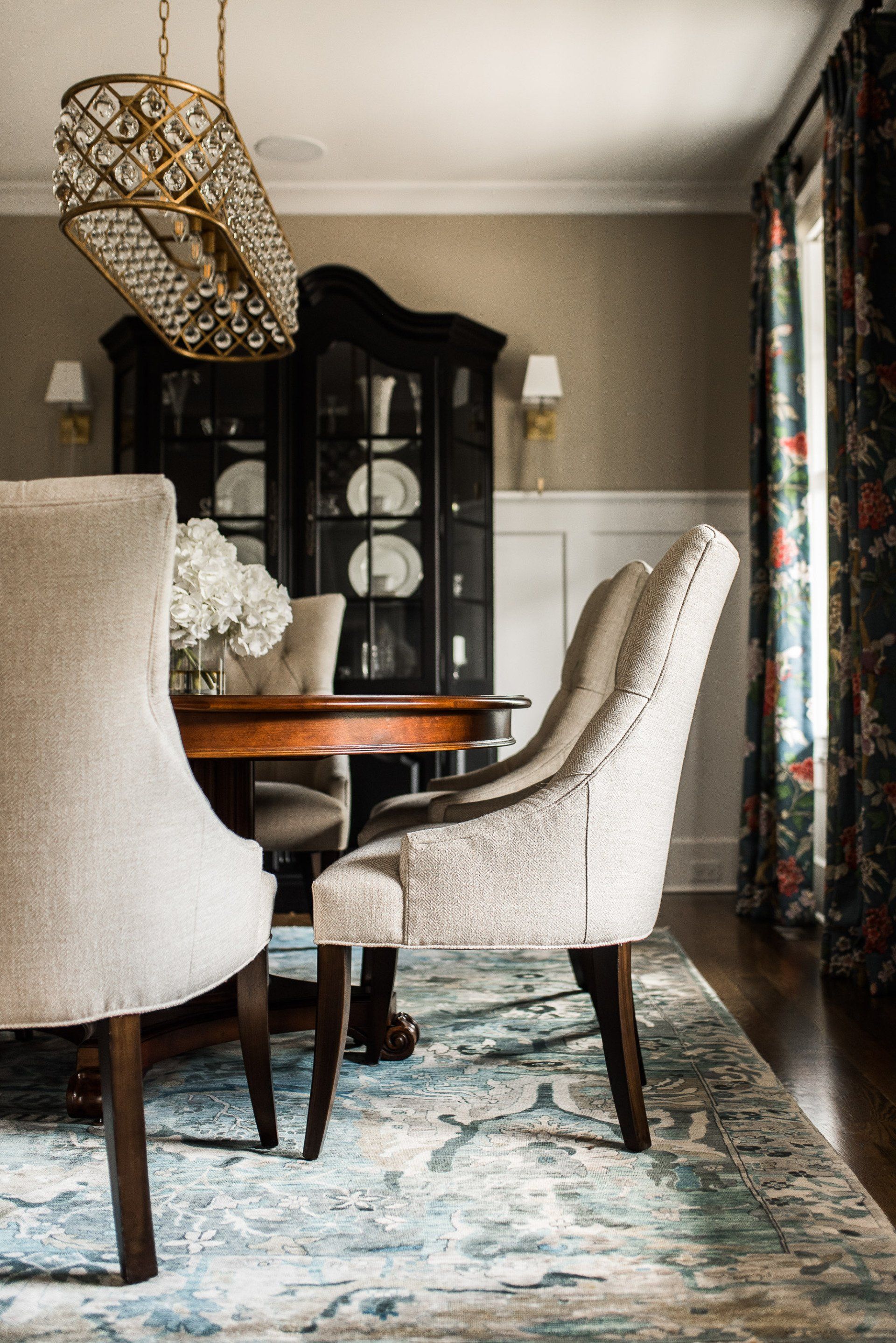 A dining room with a table and chairs and a rug.