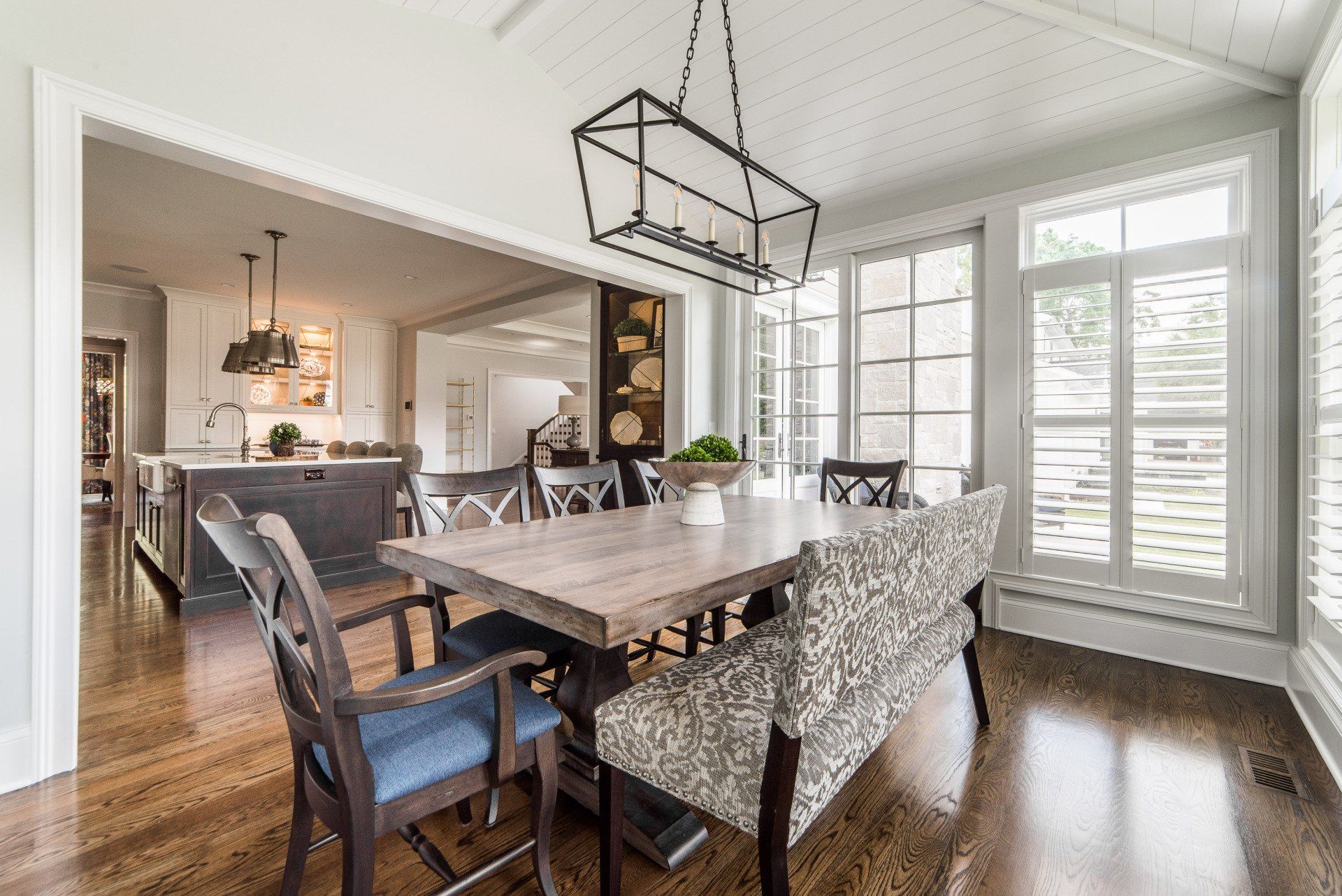 A dining room with a table and chairs and a bench.