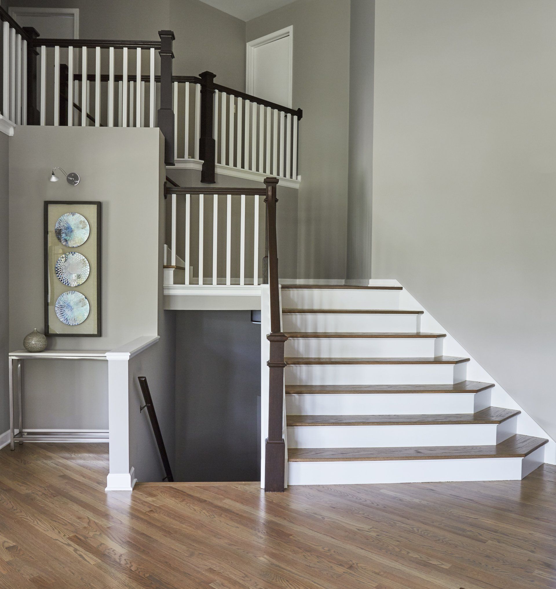 A staircase with white steps and a wooden railing