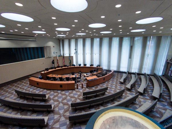 Empty modern lecture hall with curved rows of seats and large windows