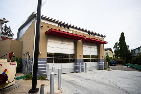 Fire station with red awnings and garage doors on a quiet street