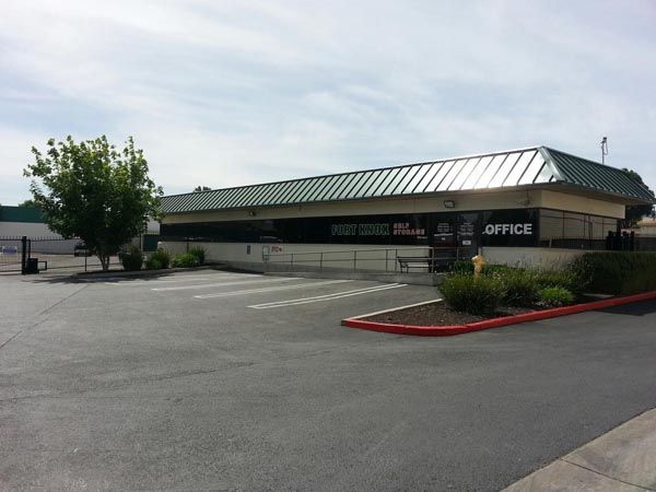 Low-rise office building with green roof and empty parking lot on a sunny day