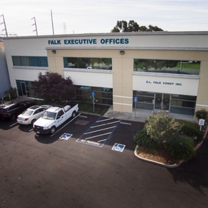 Falk Executive Offices building with parked cars and accessible parking spaces in front