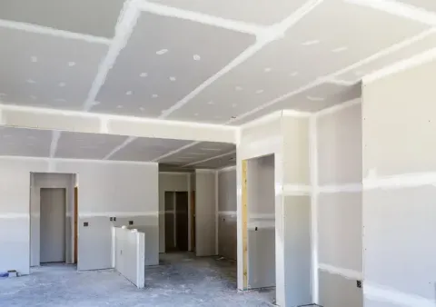 Habitación vacía sin terminar, con paneles de yeso, juntas encintadas y entradas en construcción