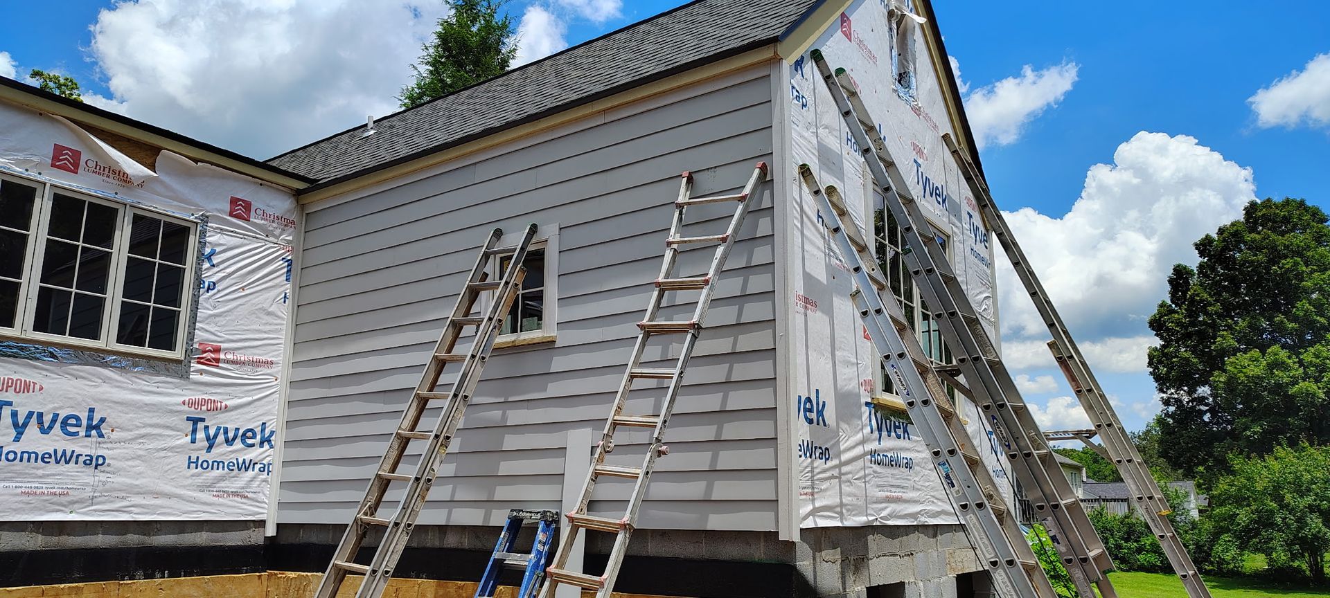 A house is being remodeled with a ladder on the side of it.