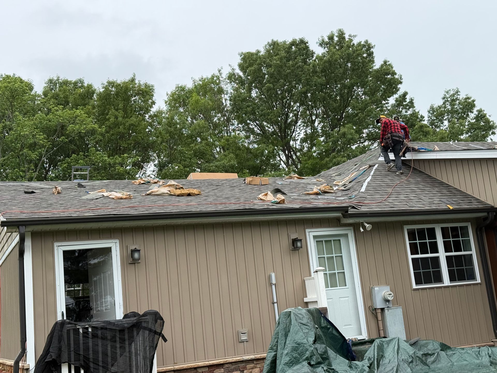 A man is standing on the roof of a house.