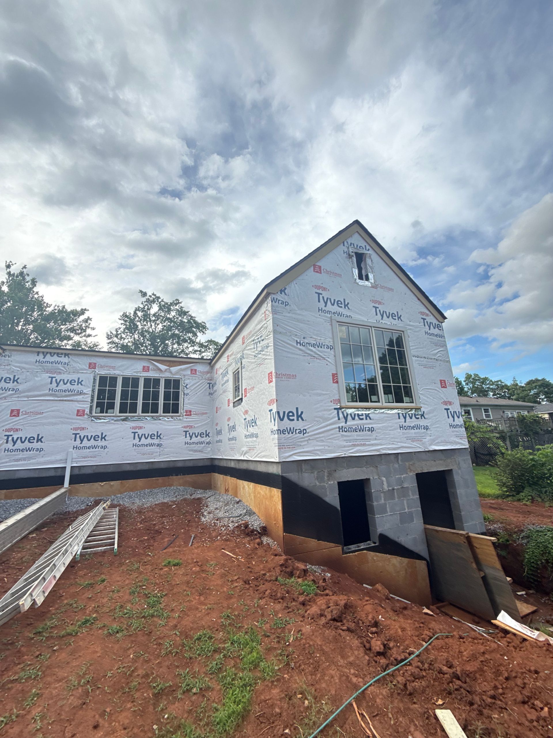 A house is being built on top of a dirt hill.