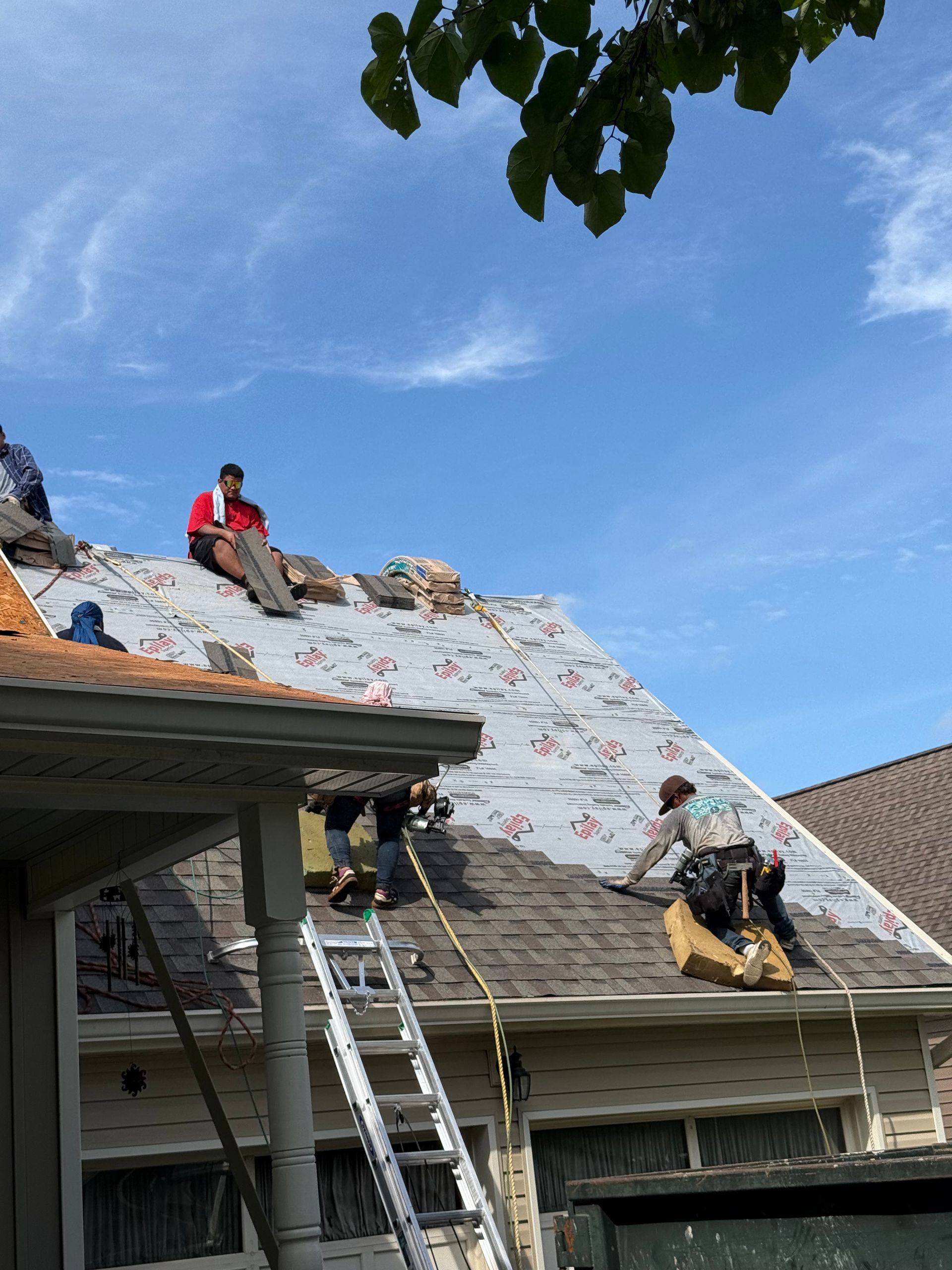 A group of men are working on the roof of a house.