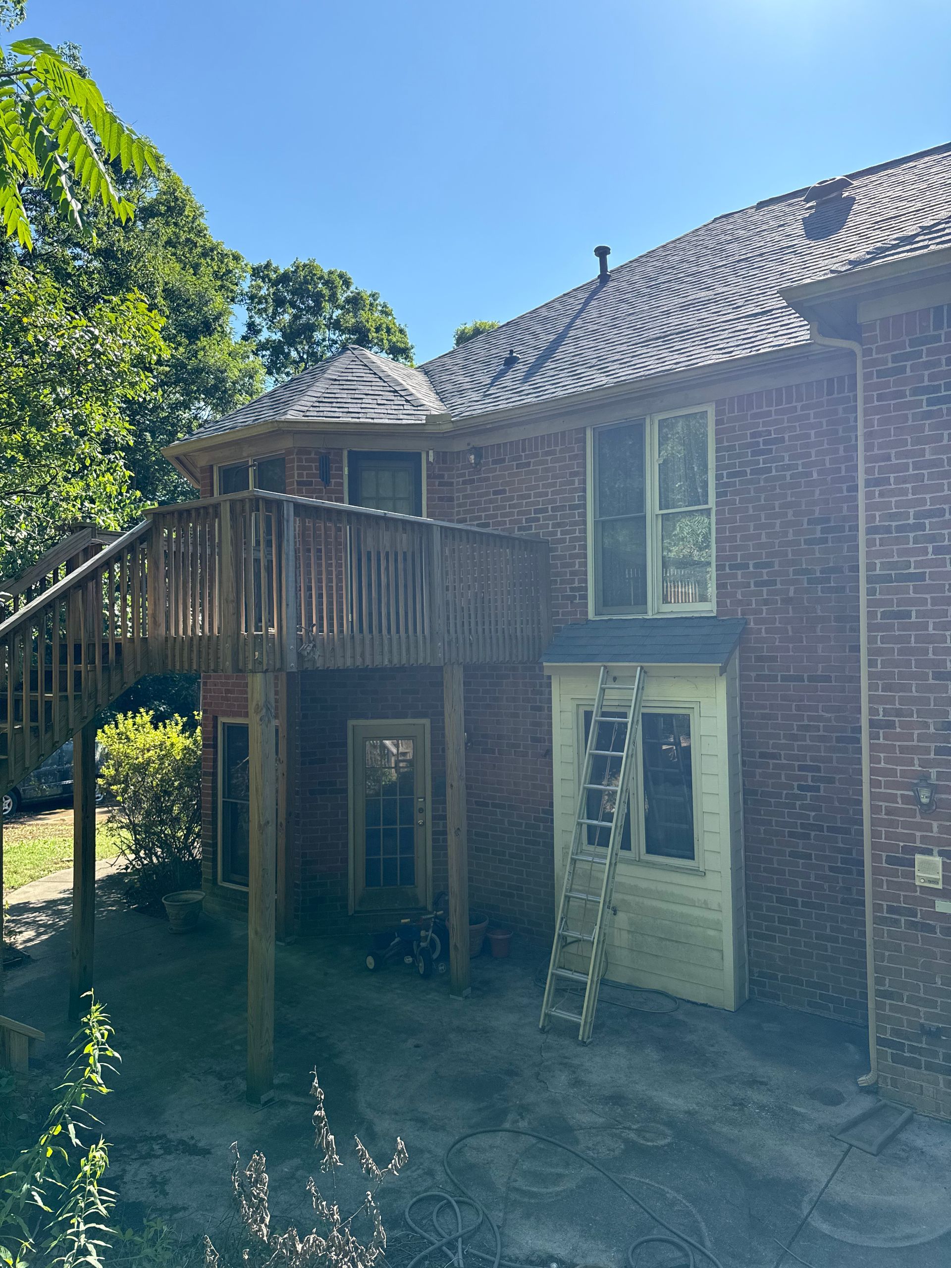 A brick house with a wooden deck and stairs
