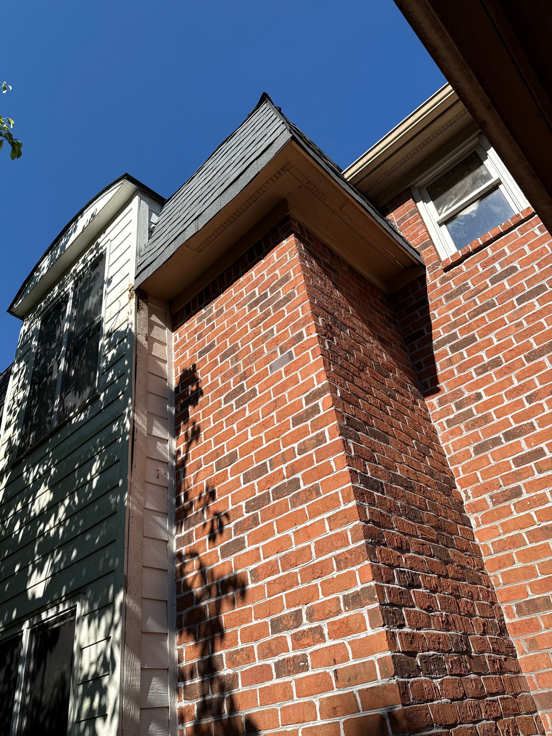 A brick building with a chimney on the side of it