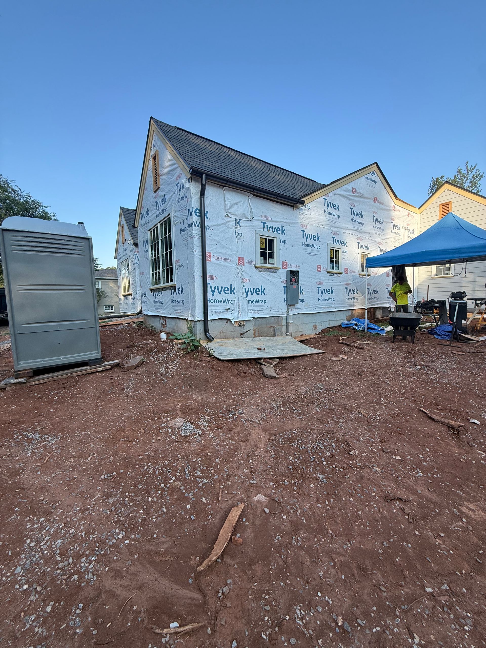 A house is being built in the middle of a dirt field.