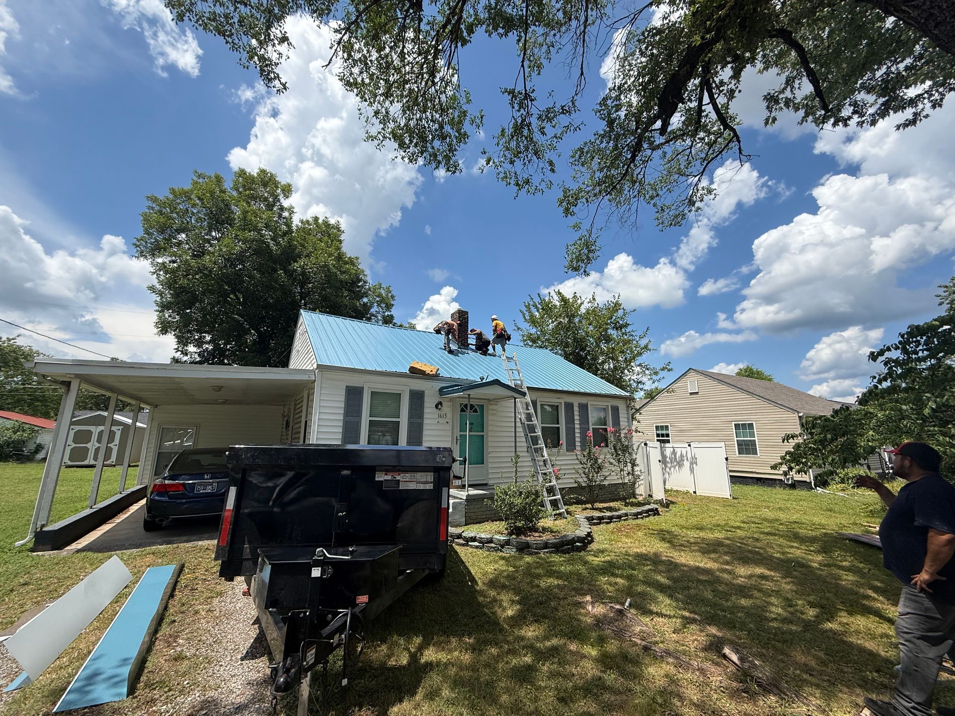 Two men are working on the roof of a house.