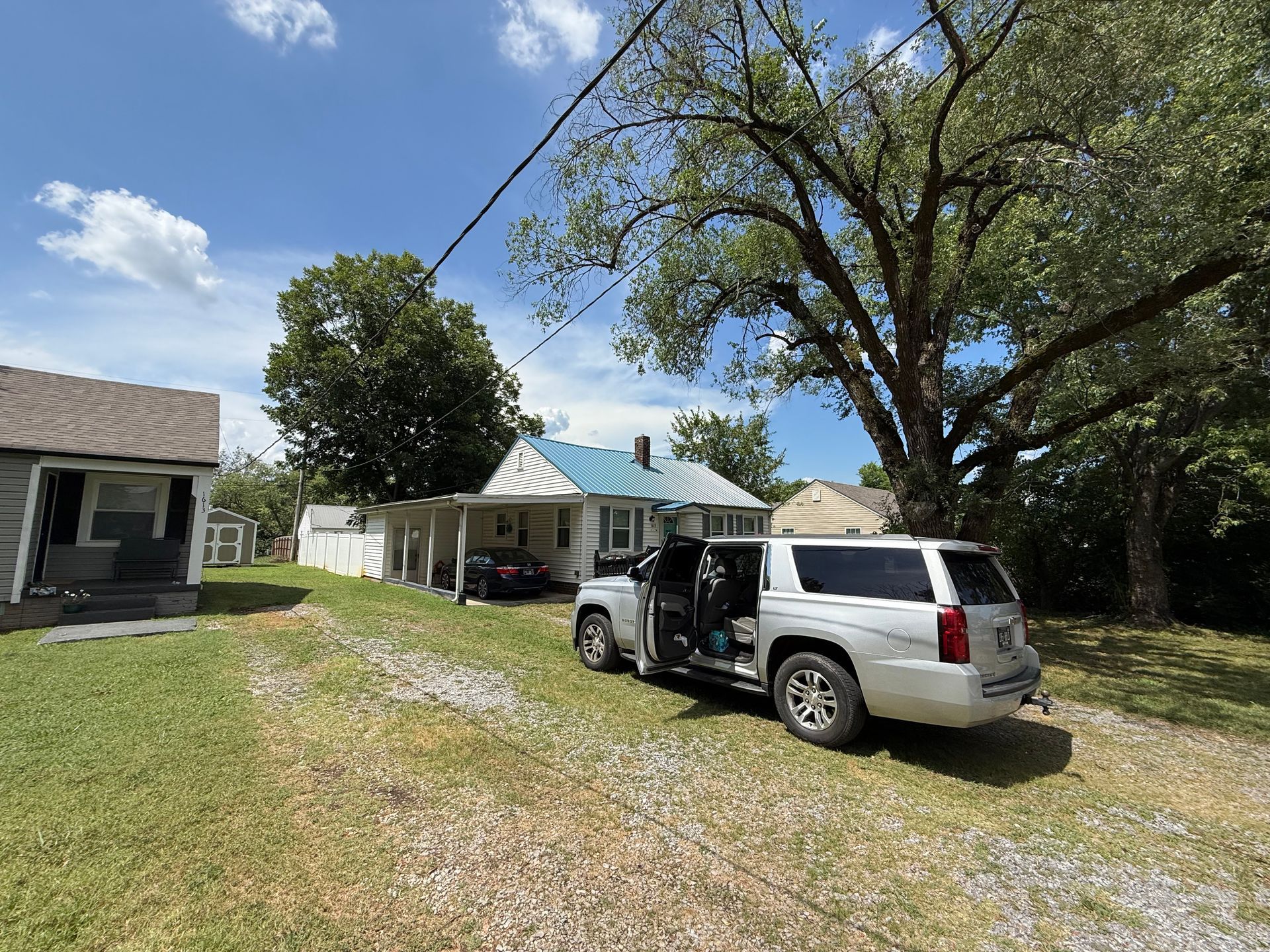 A silver suv is parked in front of a house.