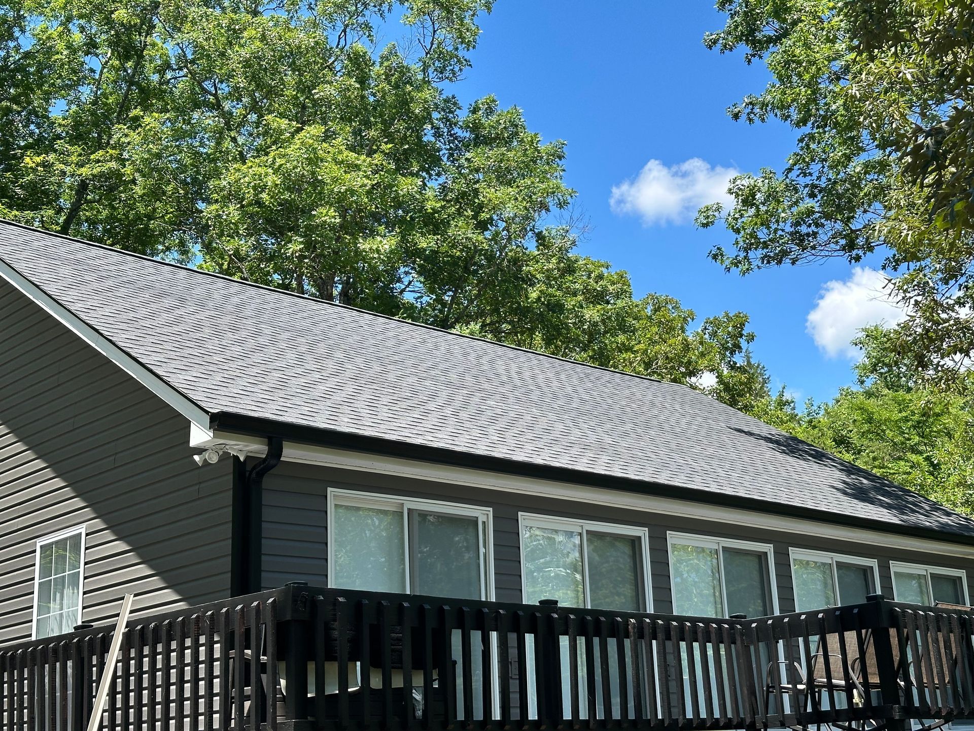 A house with a gray roof and a black deck