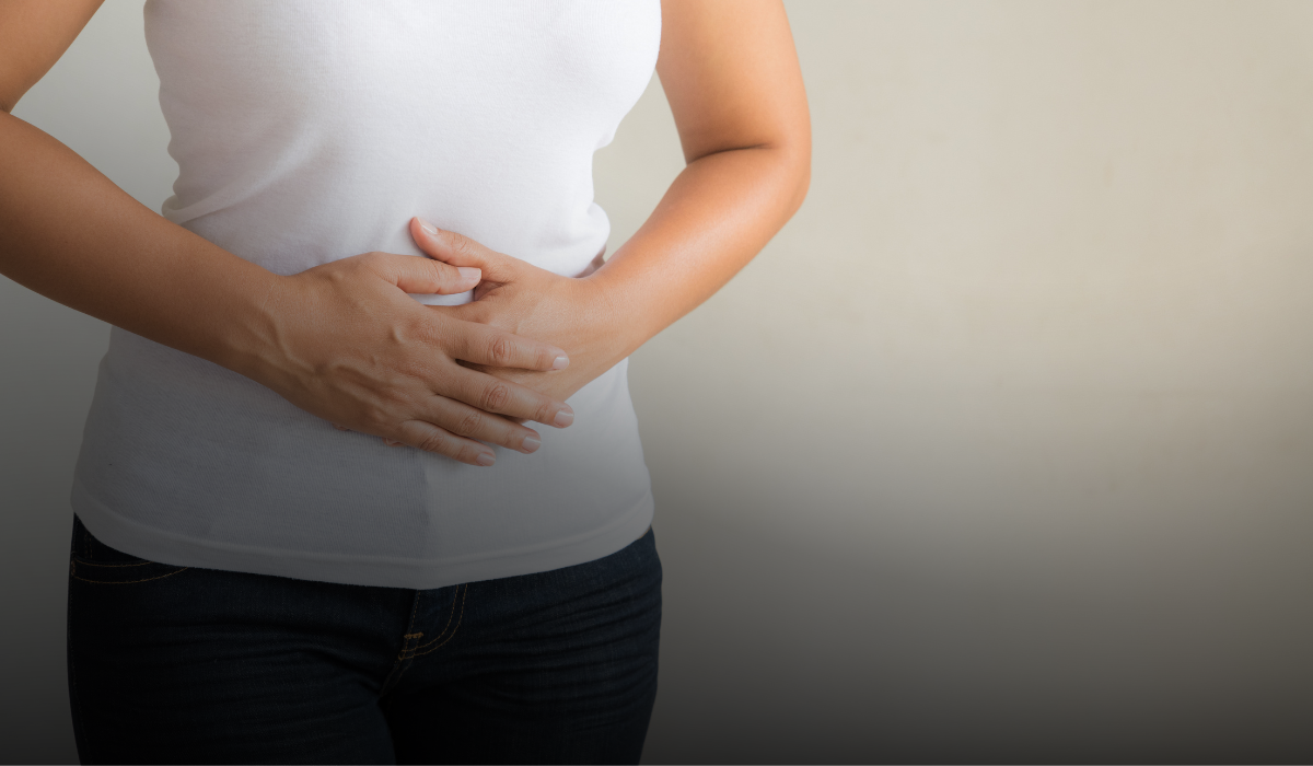 Person with hands folded over stomach, suggesting discomfort