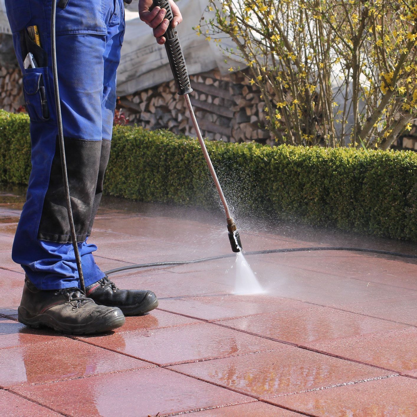 Worker pressure washing patio pavers for professional driveway and outdoor surface cleaning services. Worker pressure washing patio pavers for professional driveway and outdoor surface cleaning services.