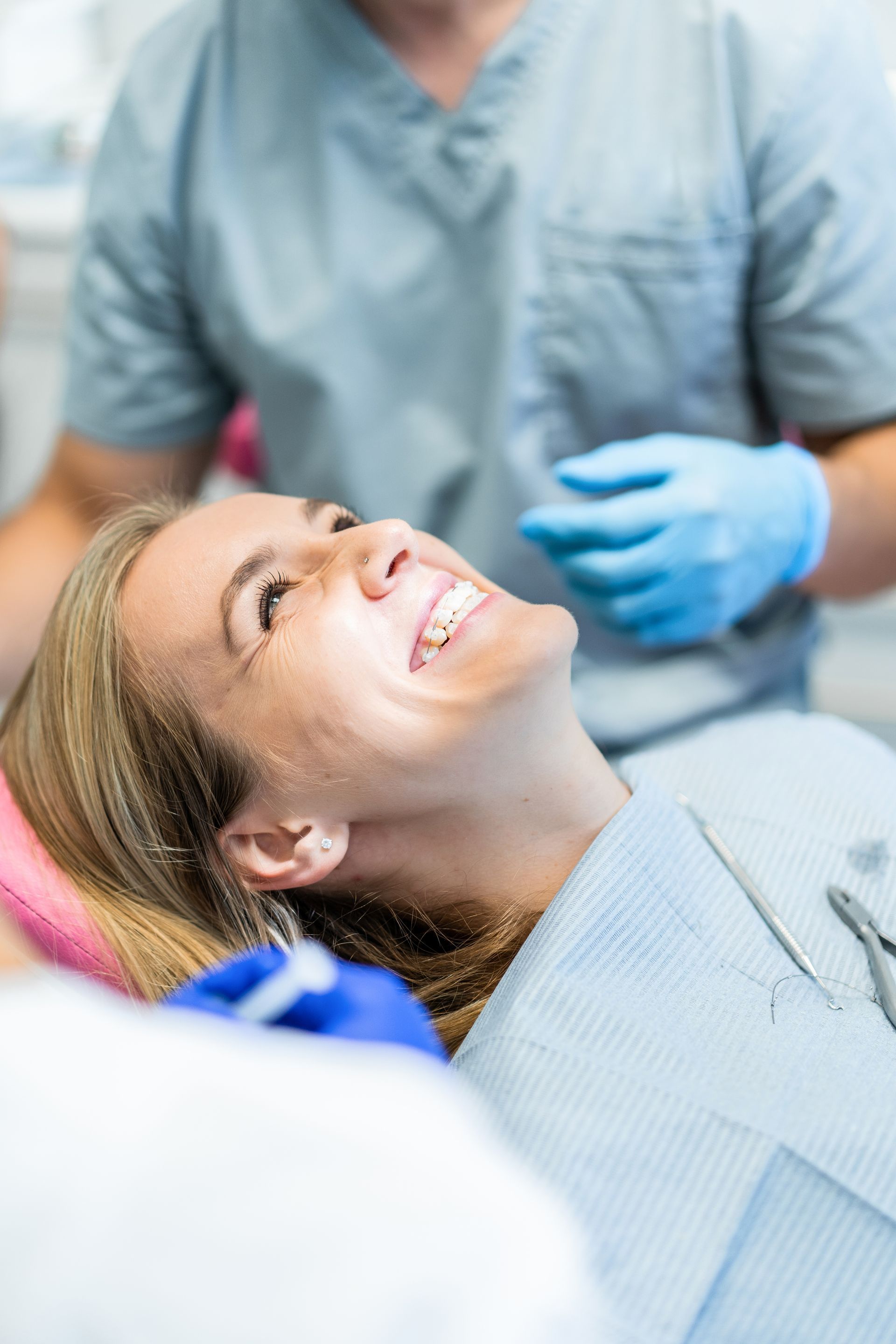 Odontologia a Moma Clinic Andorra. Una mujer sonríe mientras está sentada en un sillón dental.