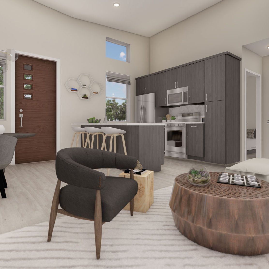 Modern living room with kitchen, gray cabinets, wooden accents, and a round coffee table.