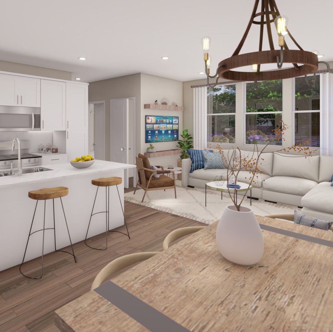 Open-concept kitchen and living area with white cabinets, light wood floors, and a sectional sofa.