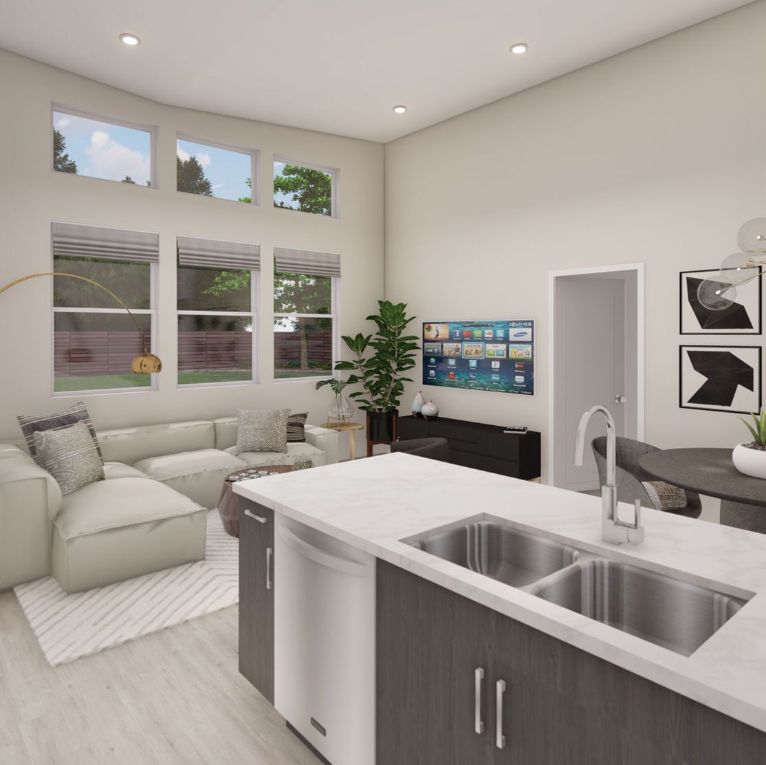 Modern kitchen with island, living area with couch, and large windows.