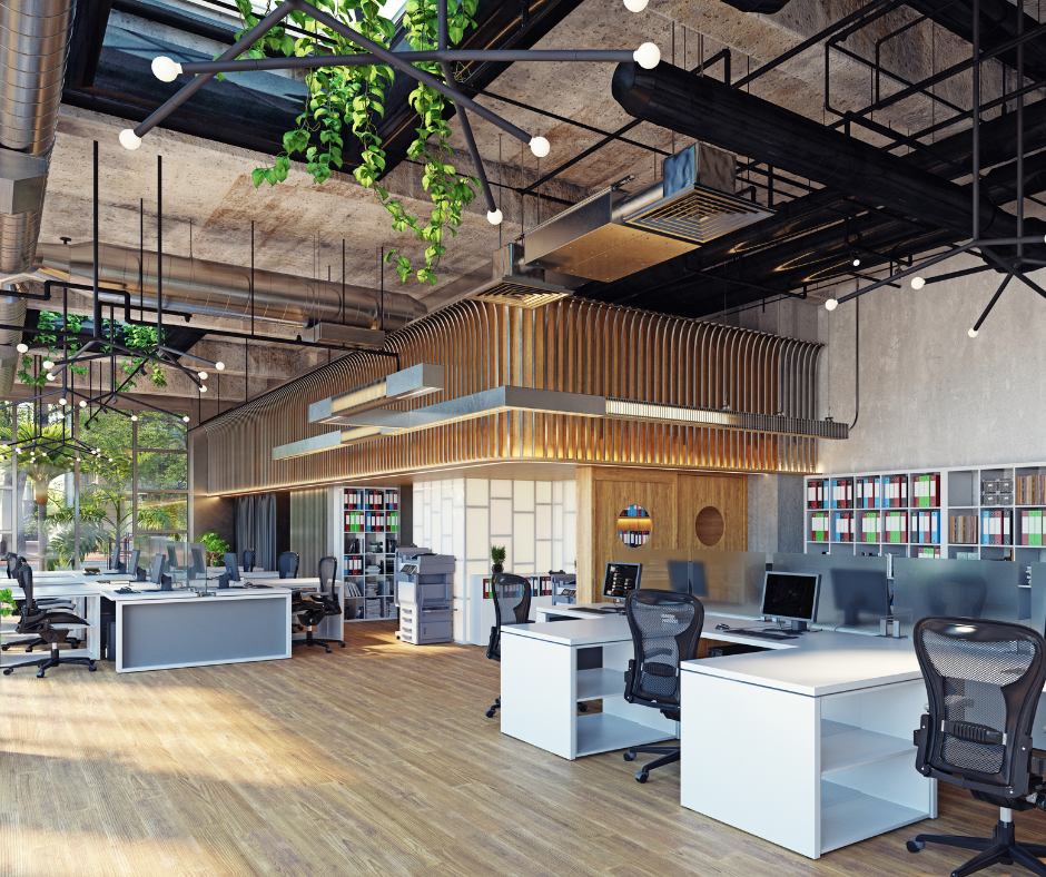 Modern open-plan office with desks, rolling chairs, wood floors, and hanging plants under an industrial ceiling