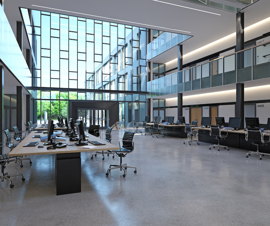 Modern open-plan office with desks, computers, glass walls, and a large skylit atrium