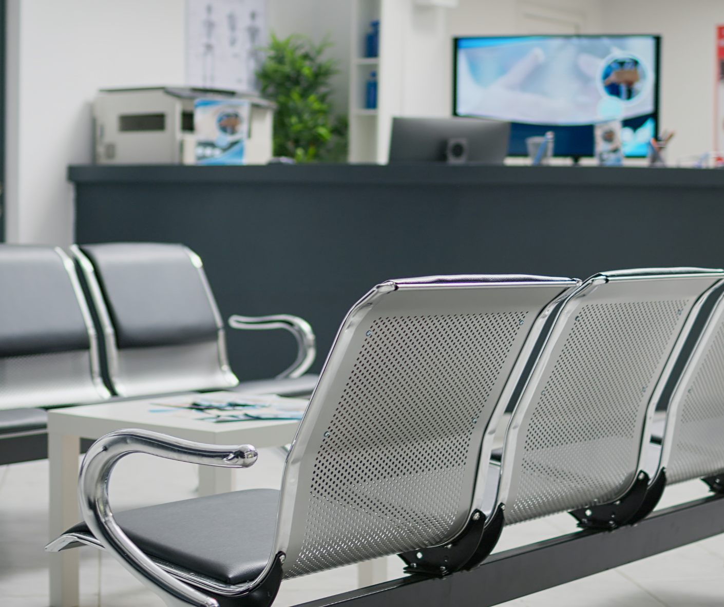 Empty airport waiting area with metal benches and a departure desk in the background Empty airport waiting area with metal benches and a departure desk in the background