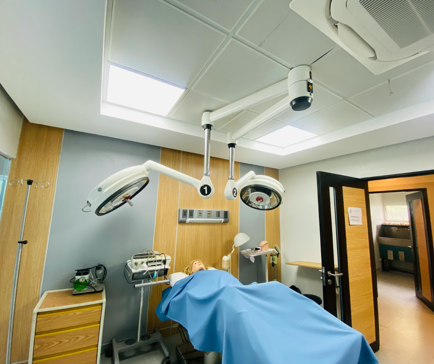 Empty hospital operating room with surgical lights and a blue-draped table Empty hospital operating room with surgical lights and a blue-draped table