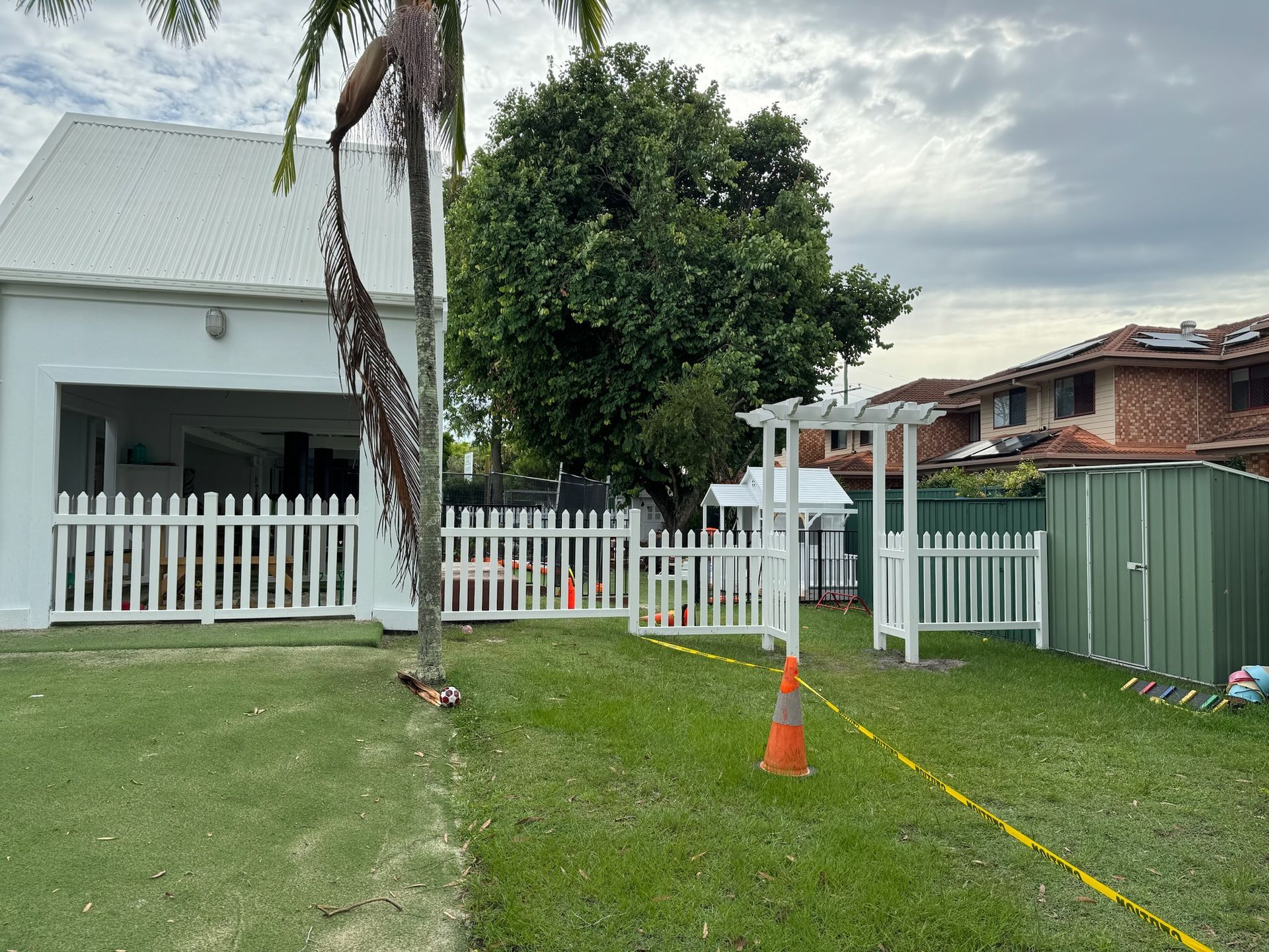 A white house with a white picket fence in front of it.