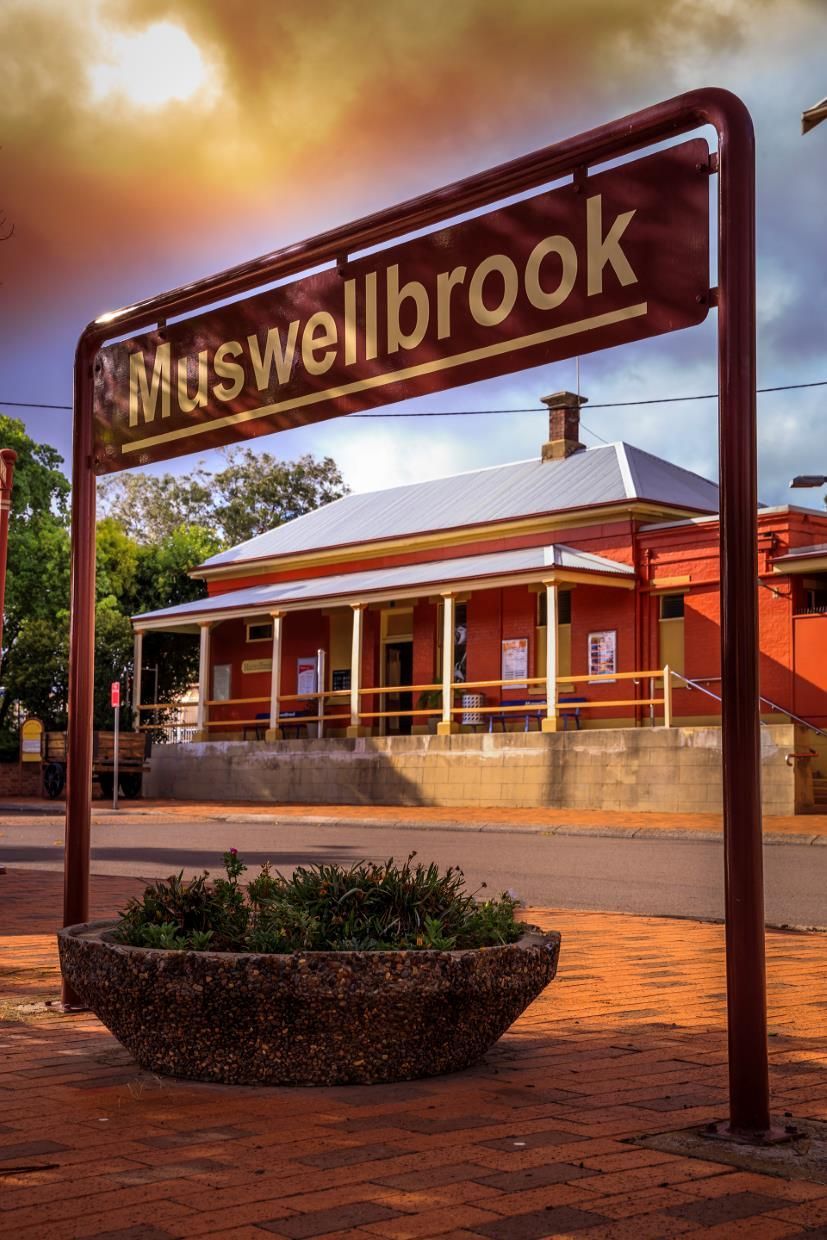 Muswellbrook Sign in Front of a Red-brick Building at Sunset — Concrete Colour Solutions in Muswellbrook, NSW