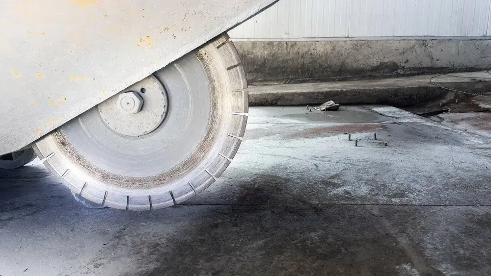 A Concrete Saw Is Cutting a Concrete Floor — Concrete Colour Solutions in Port Stephens, NSW