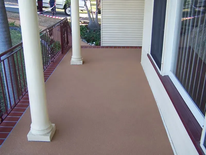 A porch with white columns and a brown carpet — Concrete Colour Solutions in Morisset, NSW