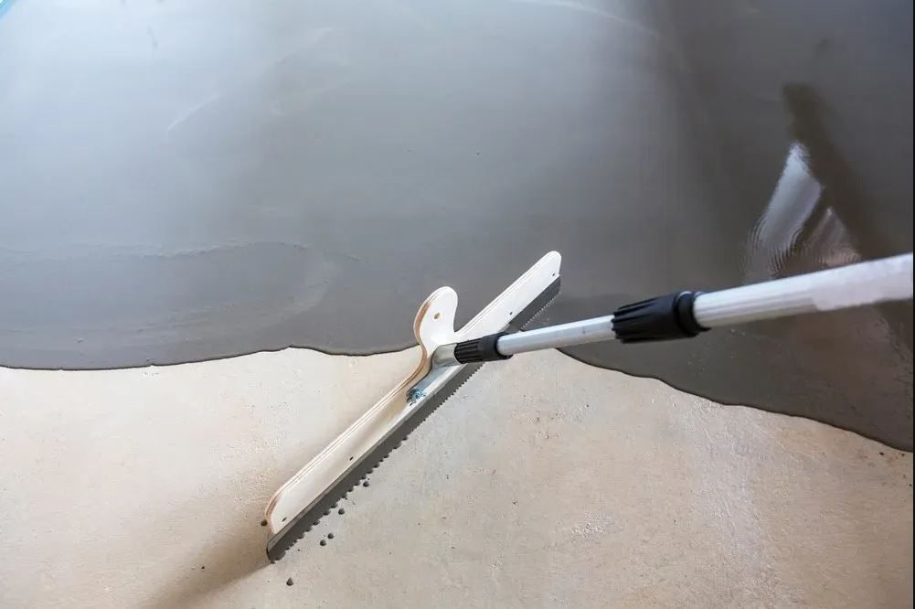 Paint Roller Applying White Paint Along the Edge — Concrete Colour Solutions in Denman, NSW